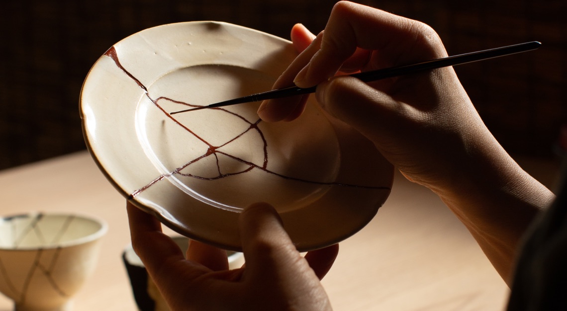 Photo of someone performing kintsugi on a plate