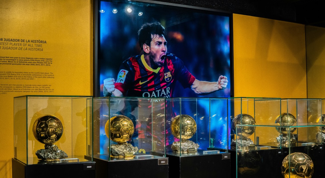 Ballon d'or trophies in front of a panel of Lionel Messi