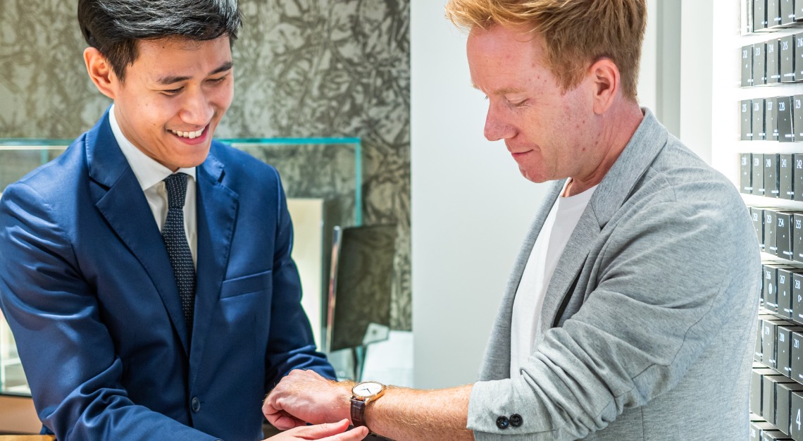 boutique staff at A. Lange & Söhne helping a man try on a watch