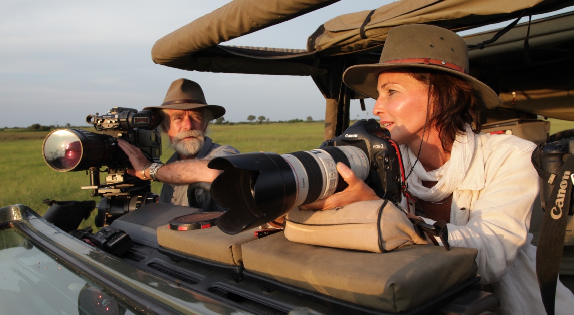 Dereck and Beverly Joubert in a jeep in Africa with cameras