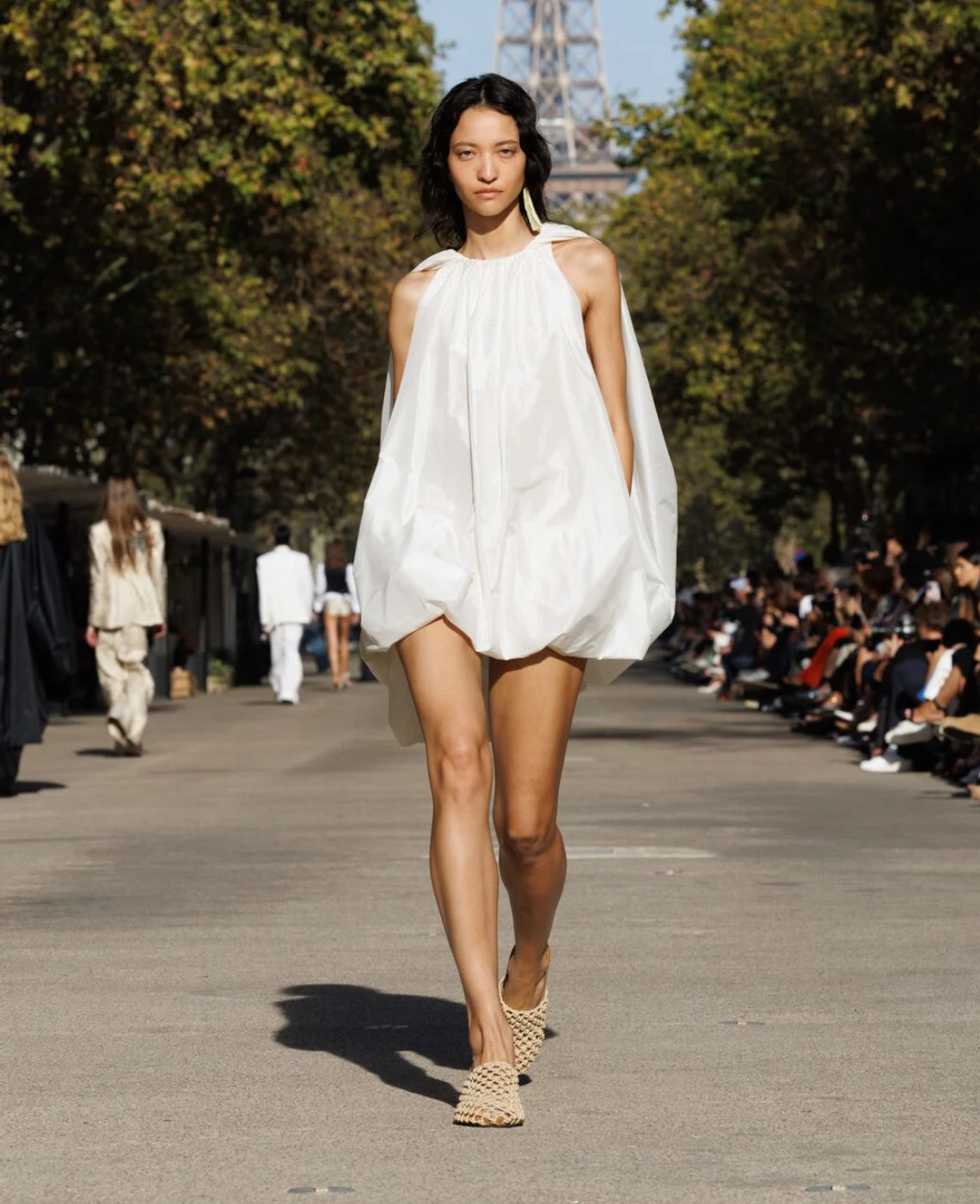 model in a white dress on a runway