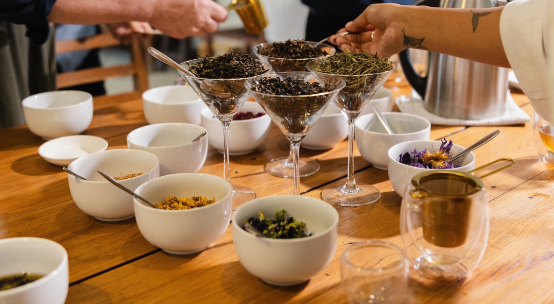 an array of glasses and bowls with loose tea leaves and ingredients