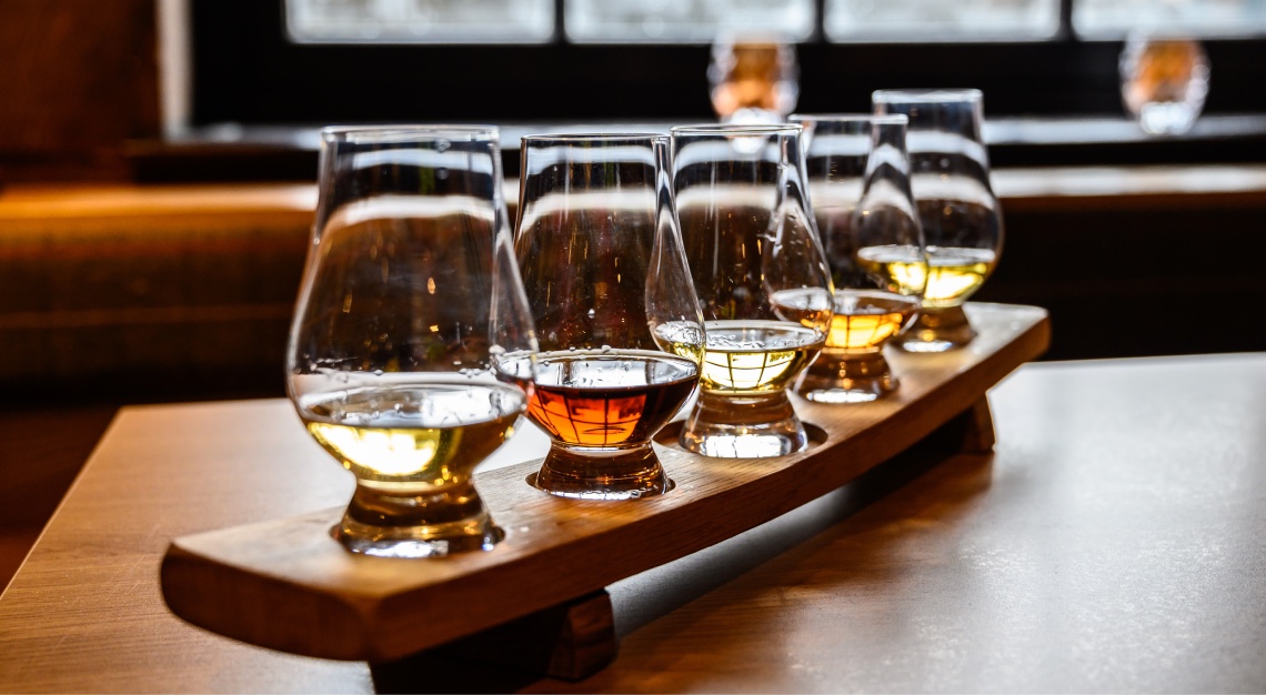 Collection of Scottish whisky, tasting glasses with variety of single malts or blended whiskey spirits on distillery tour in Scotland