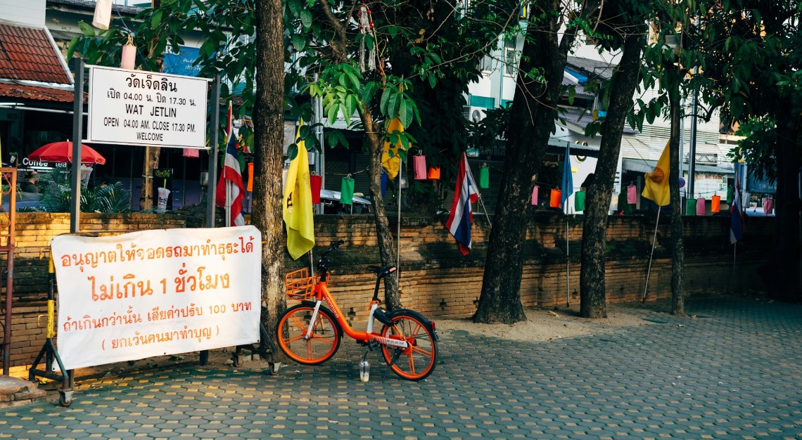 a bicycle left next to a sign in Chiang Mai